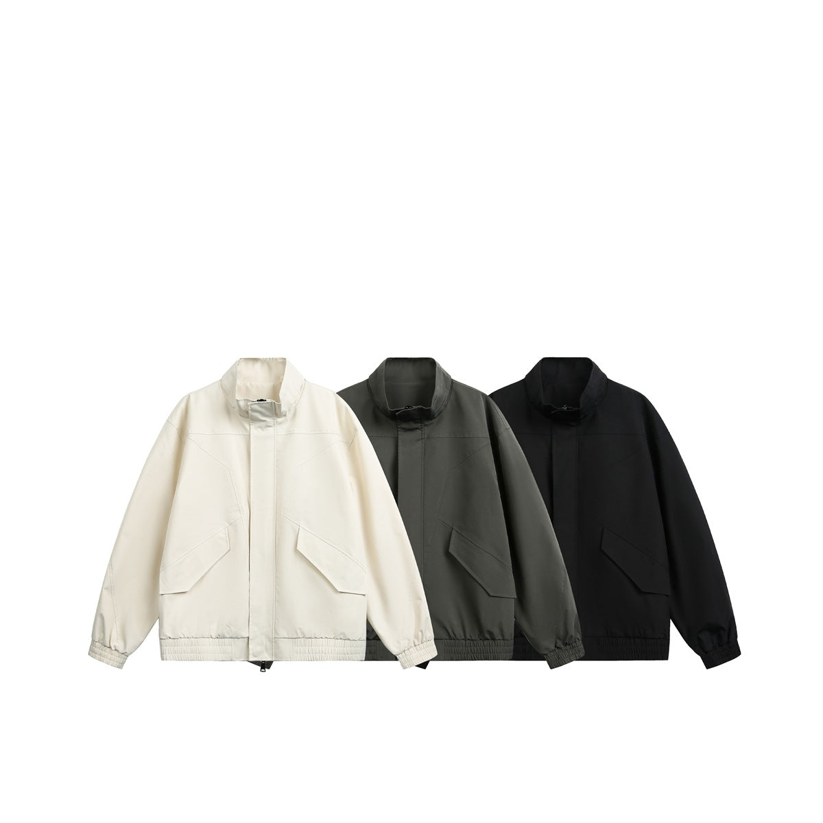 Front view of three jackets in cream, charcoal gray, and black, with high collars and flap pockets.