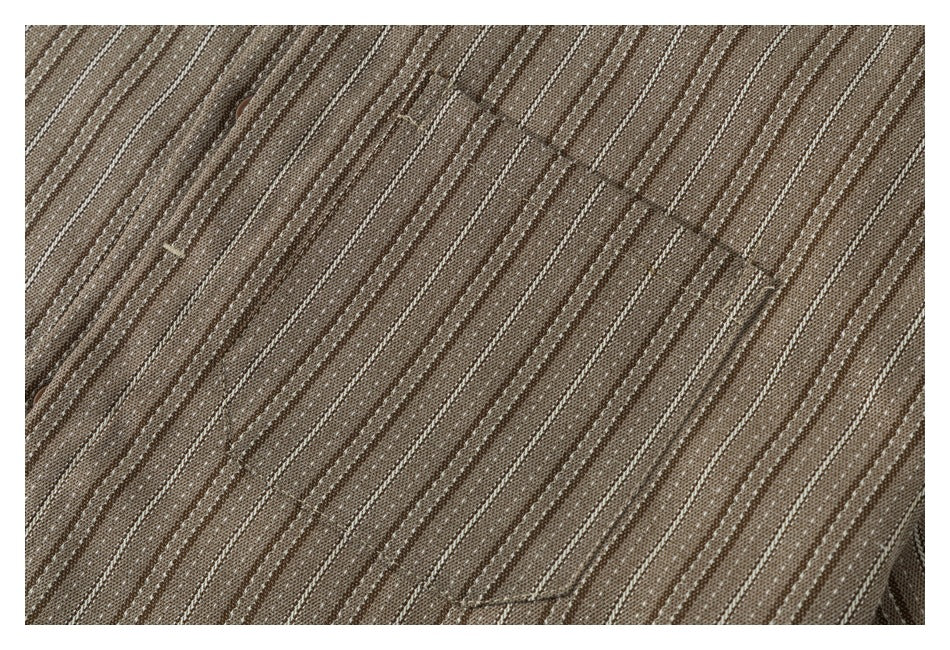 Close-up of a brown shirt showing a stitched chest pocket and narrow cream stripes.