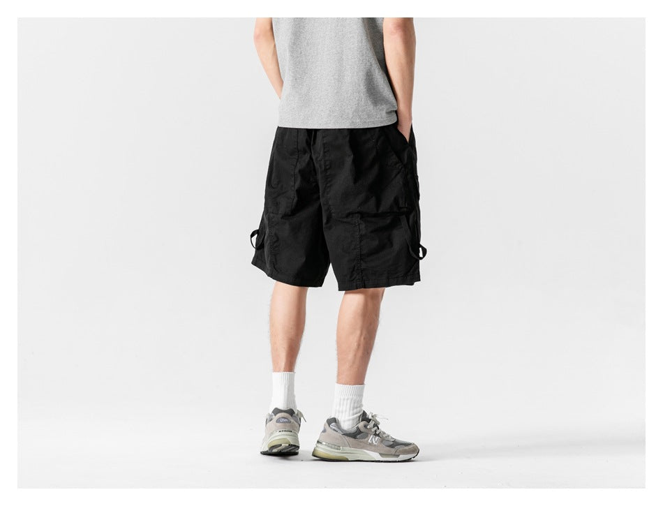 Back view of a model wearing black cargo shorts with side loops.