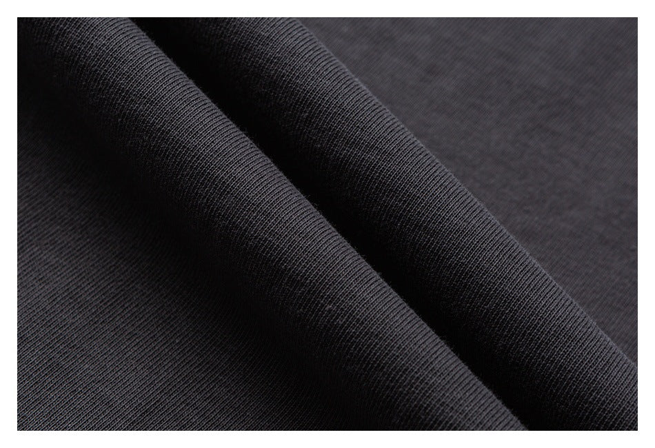 Close-up of the charcoal shirt fabric gathered into folds, showing its knit texture.