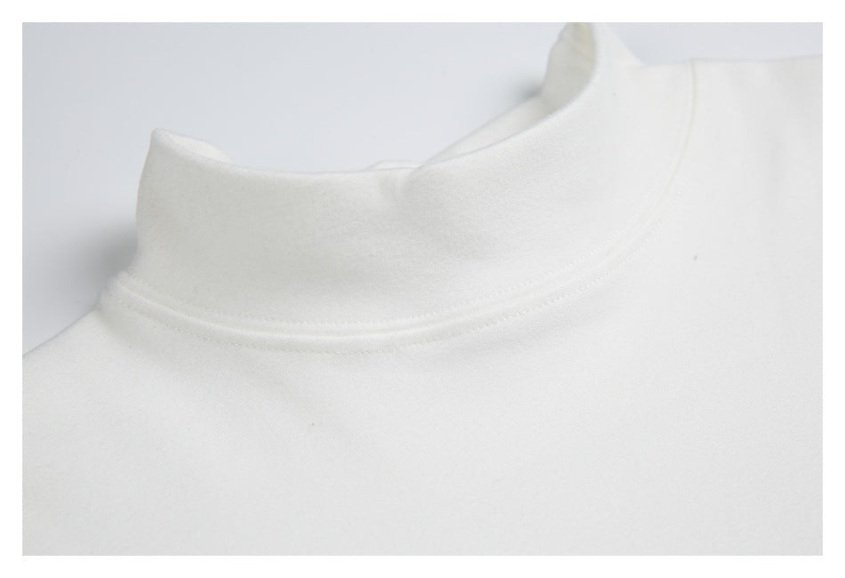 Close-up of the white shirt's mock neck and curved neckline stitching.