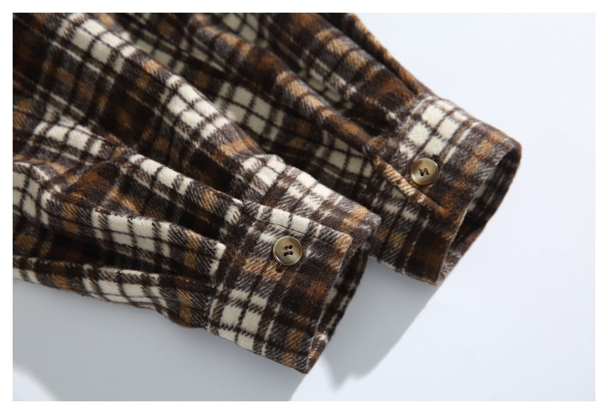 Close-up of two buttoned cuffs on a brown, tan and cream plaid shirt.