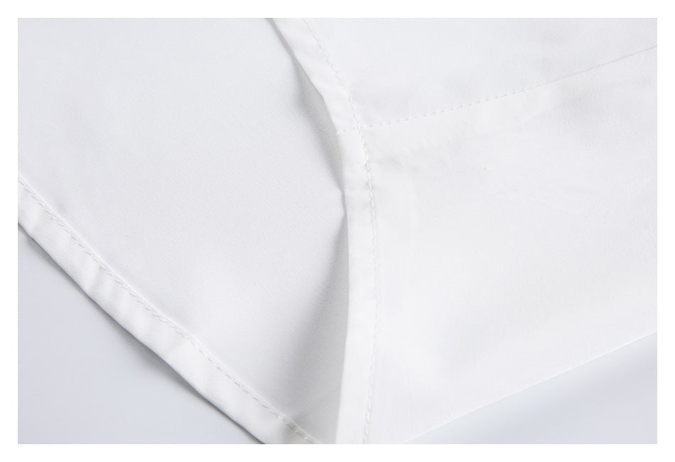 Close-up of stitched seams and panel construction on a white garment.