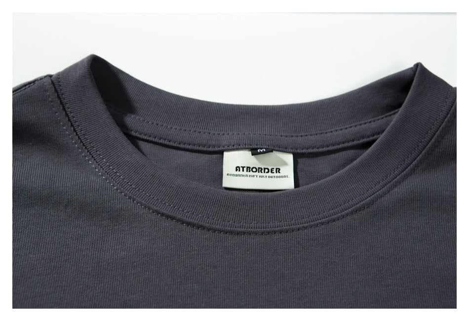 Close-up of the charcoal-gray shirt's crew neck and sewn-in brand and size labels.