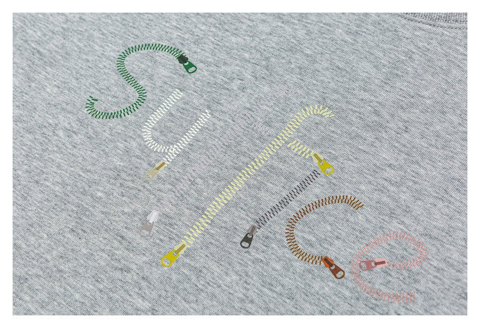 Close-up of colorful zipper-shaped lettering printed on heather gray sweatshirt fabric.