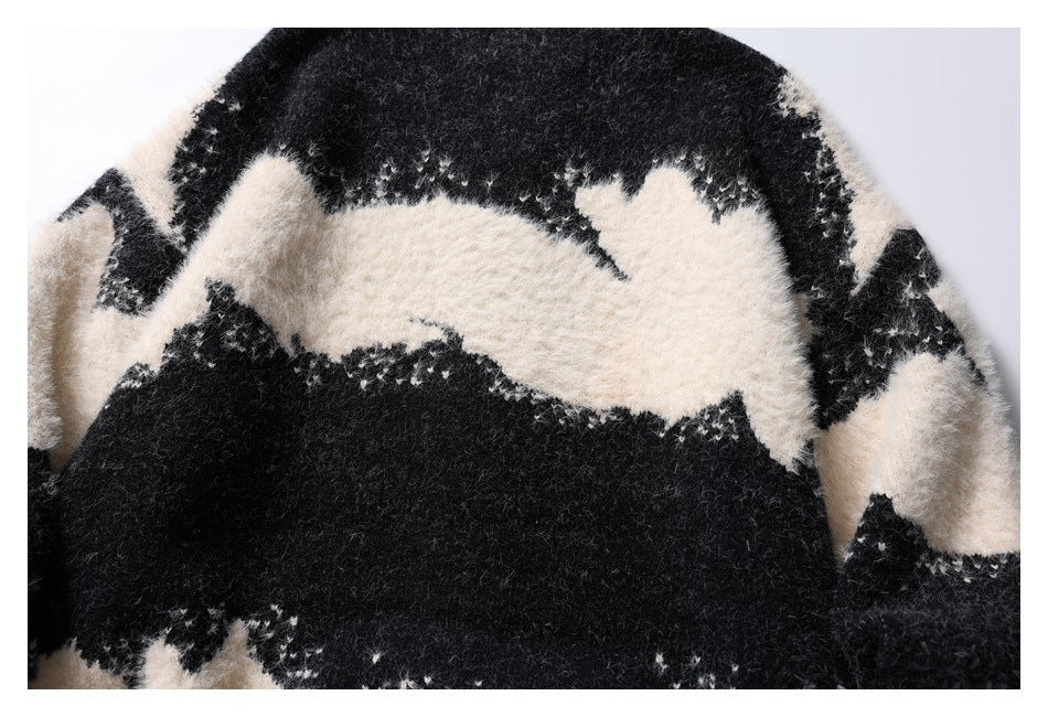 Close-up of the sweater's fuzzy black-and-ivory abstract pattern across the body and sleeves.