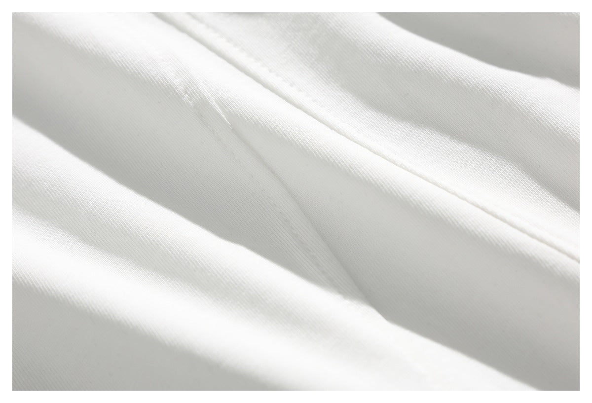 Extreme close-up of white fabric and a stitched seam.