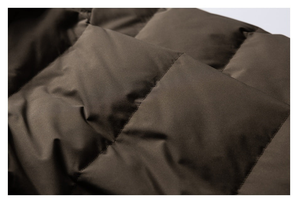 Close-up of dark brown padded jacket fabric, showing stitched panel seams.