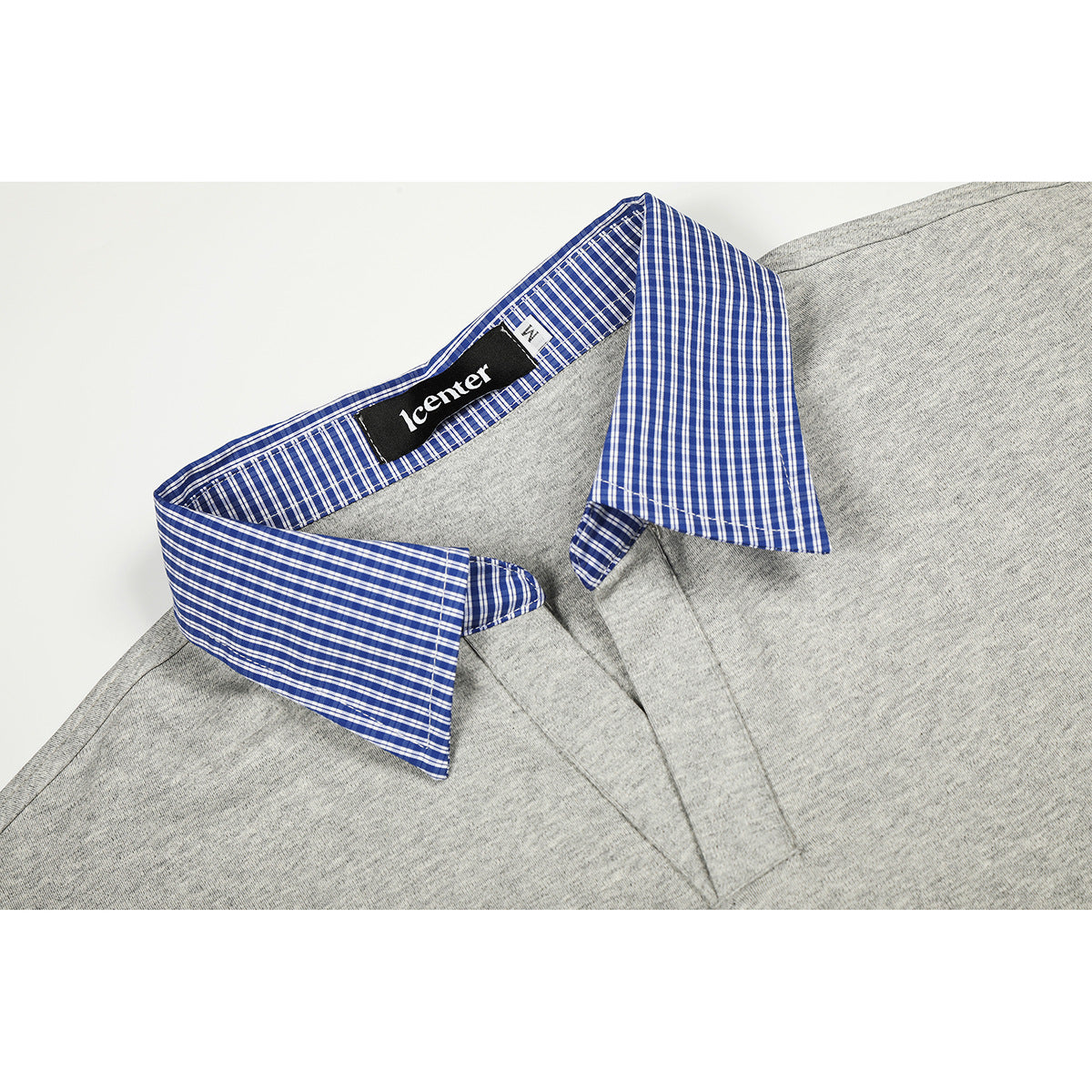 Close-up of a heather gray polo shirt with a blue-and-white check collar and a black neck label.