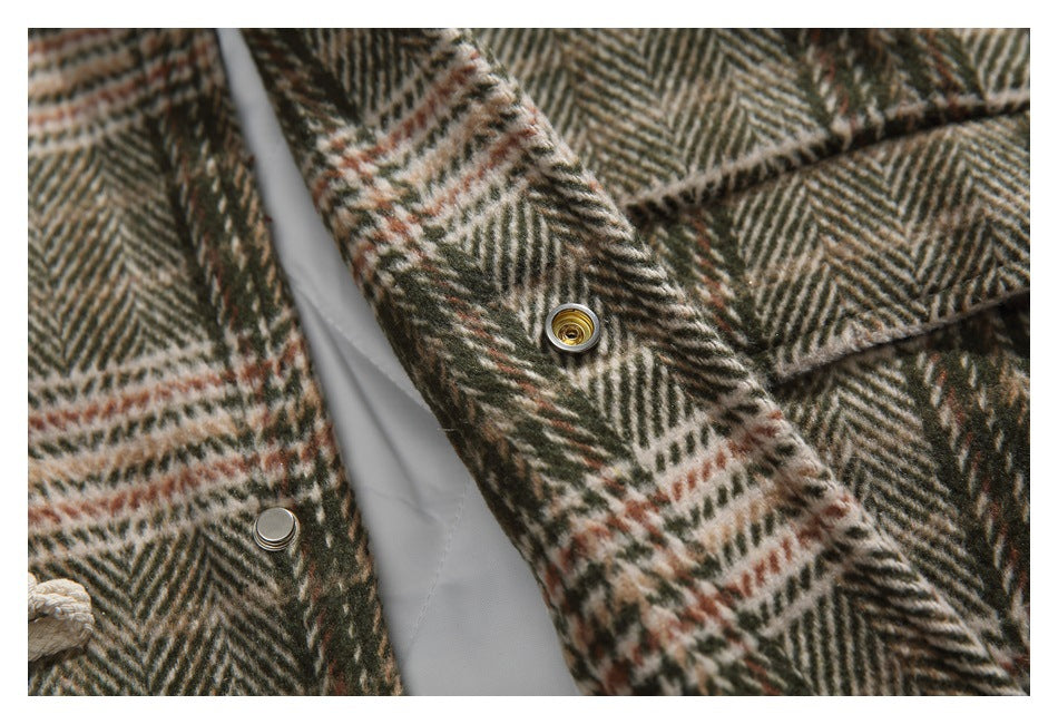Close-up of metal snap fasteners and plaid fabric along the garment opening.