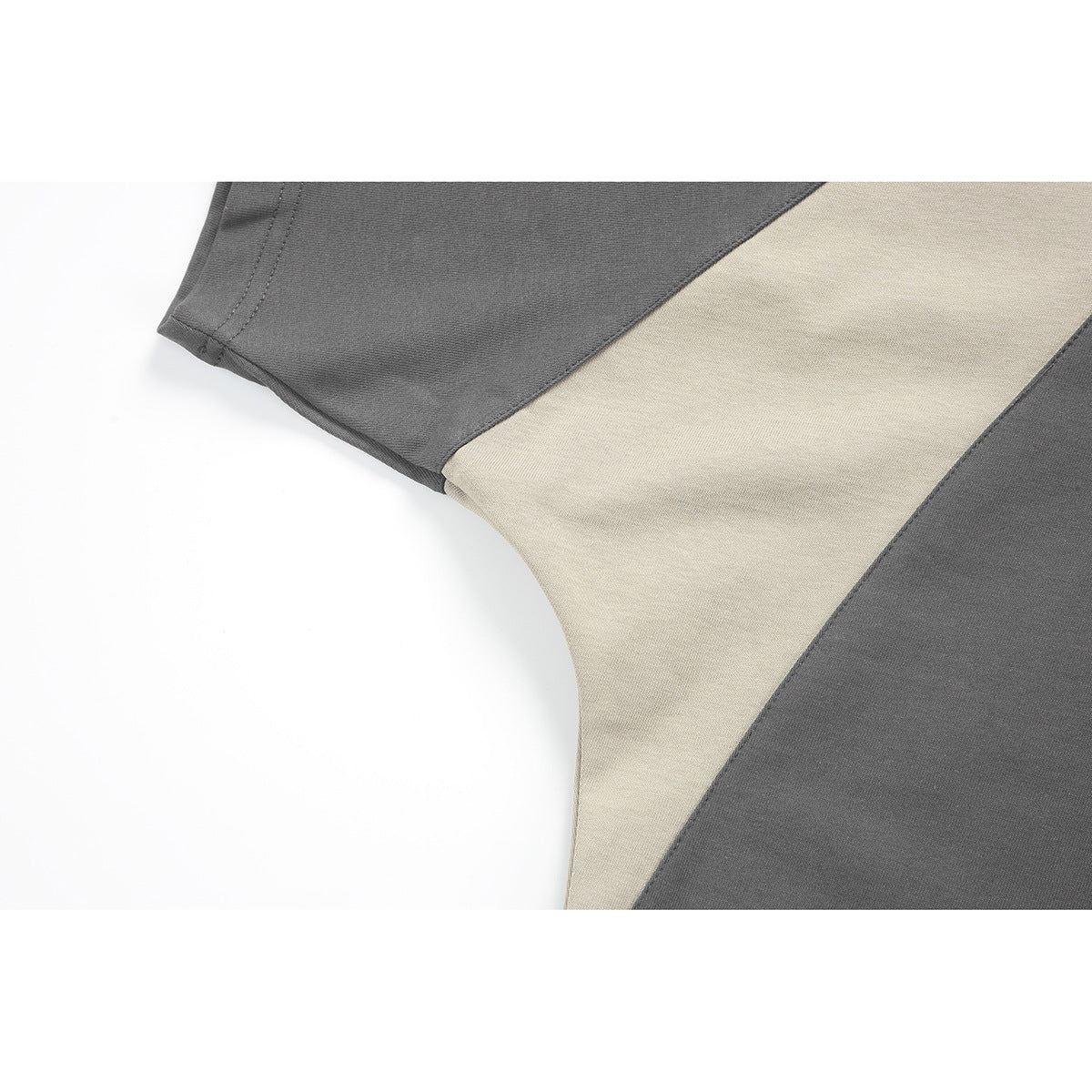 Close-up of the shirt's sleeve seam and light beige contrast panel against charcoal fabric.