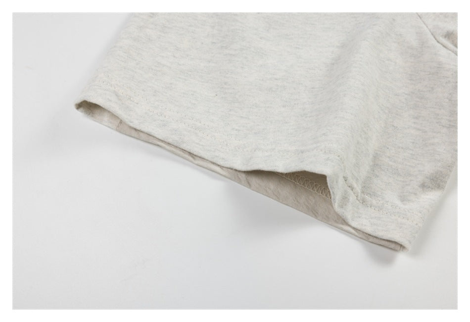 Close-up of a pale heather-gray sleeve opening with visible inner overlock stitching.