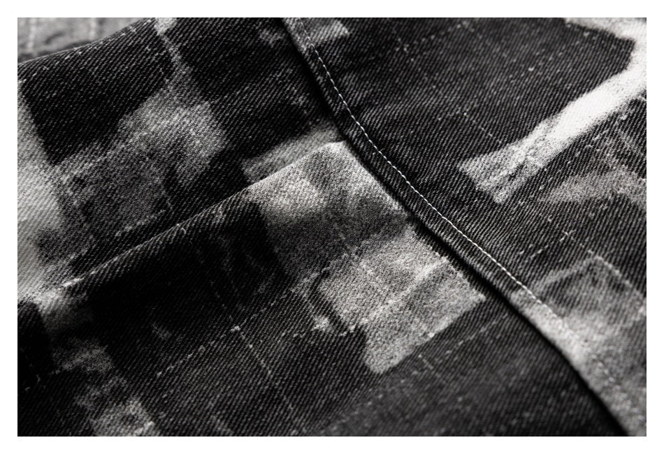 Close-up of a stitched seam across black-and-gray abstract-print fabric.