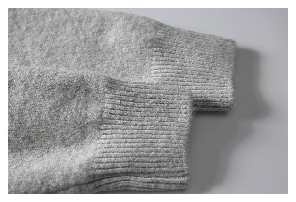Close-up of the gray sweater's ribbed sleeve cuff and knit texture.