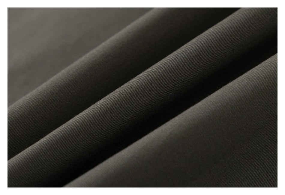 Close-up of dark olive garment fabric arranged in soft folds.