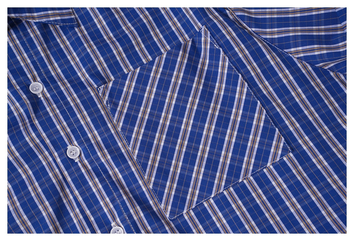 Close-up of a blue plaid shirt showing a chest pocket and white buttons.