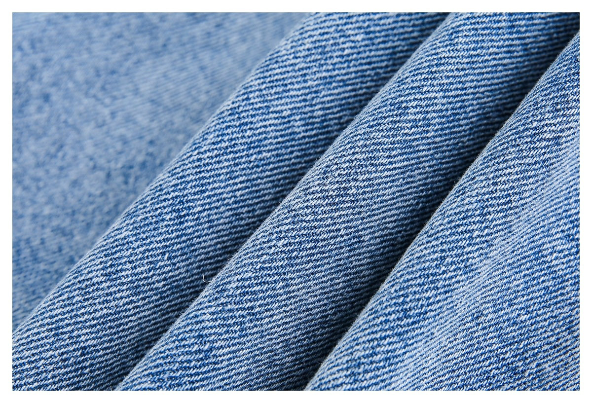 Close-up of blue denim folds showing the diagonal twill weave.