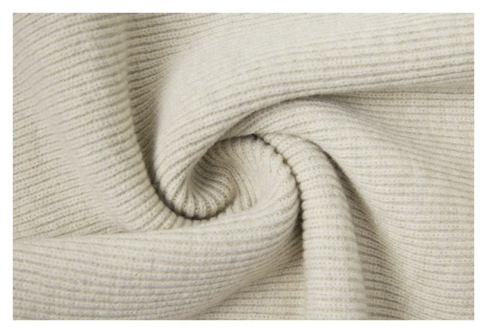 Close-up of cream rib-knit fabric folded to show its texture and drape.