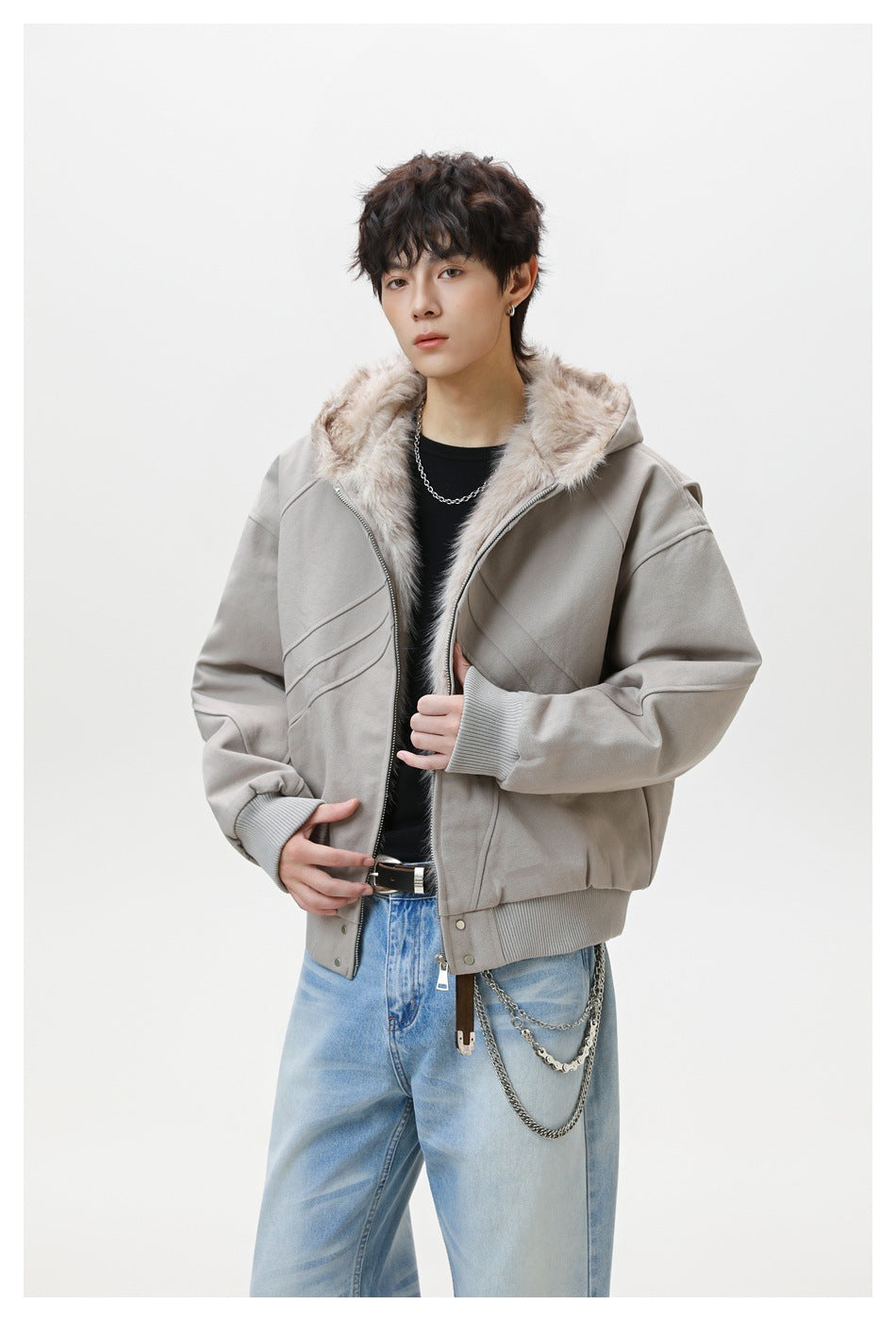 Model wearing an open light gray jacket with a plush-lined hood, ribbed cuffs, and diagonal stitched panels.