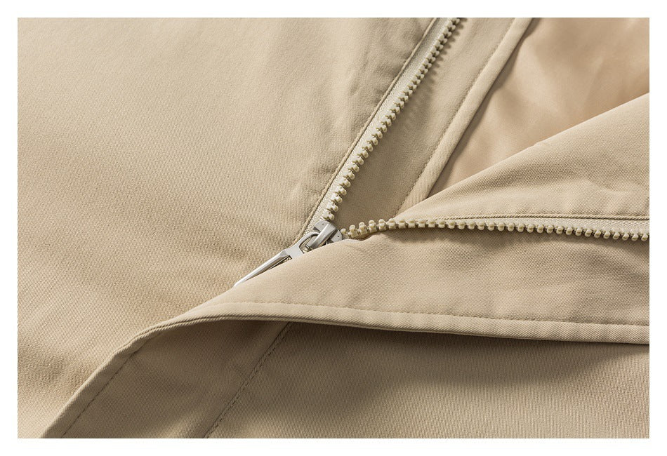 Close-up of the beige jacket's front zipper and overlapping fabric placket.