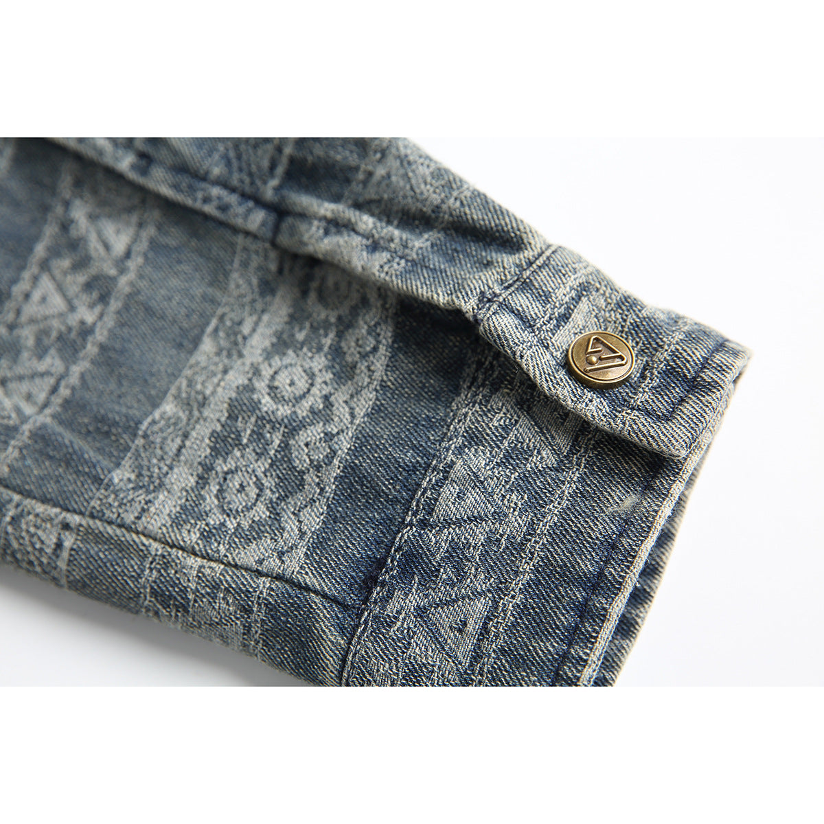 Close-up of the patterned shirt cuff and its brass-tone button.