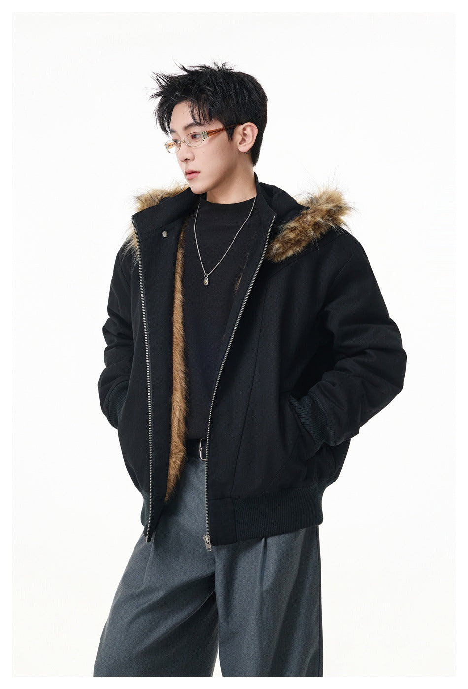 Model wearing an open black hooded jacket with brown faux-fur trim, ribbed cuffs and hem, over dark clothing.