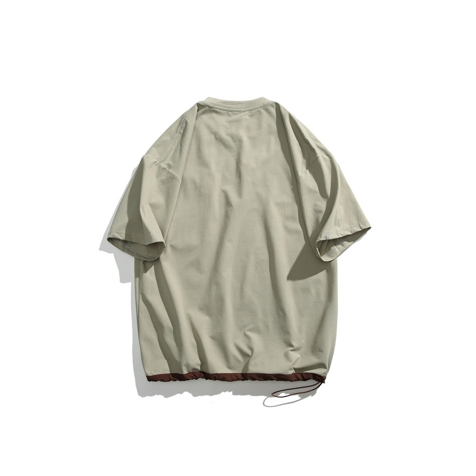 Back view of a sage-gray oversized T-shirt with a gathered dark brown hem and drawcord.