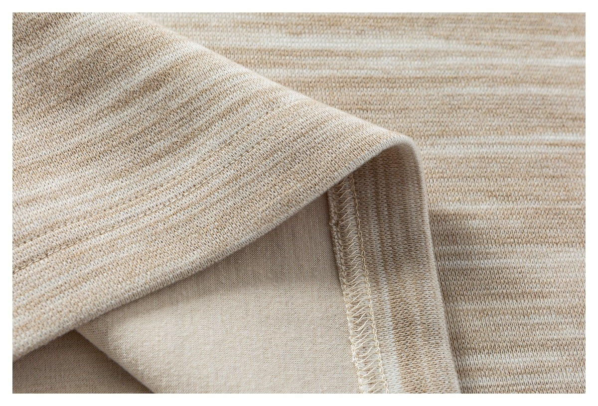 Close-up of a beige heathered knit garment's stitched hem and inner seam.