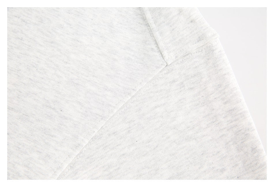 Close-up of a seam on light gray heathered sweatshirt fabric.