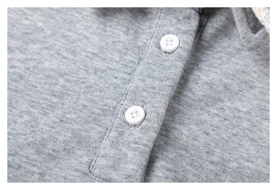 Close-up of the gray top's front placket with two white buttons.