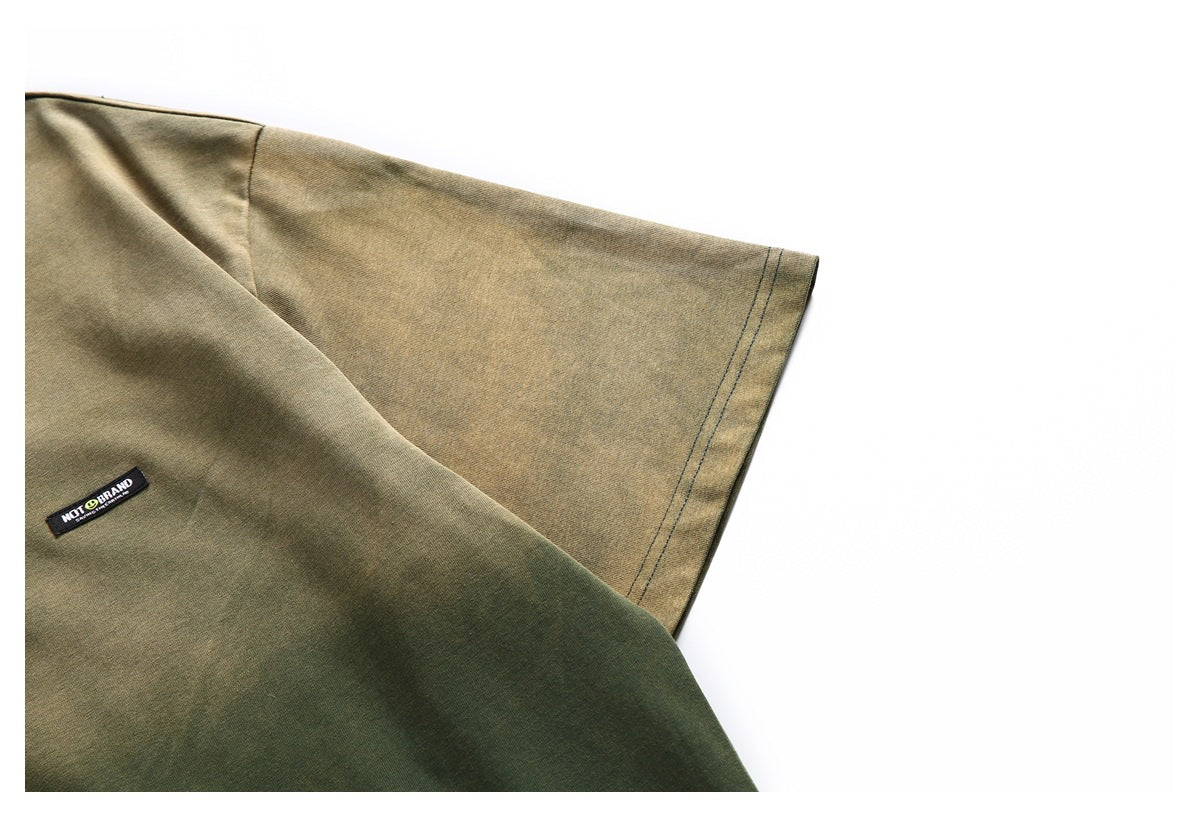 Close-up of an olive-green short sleeve and a small sewn logo patch on the shirt body.
