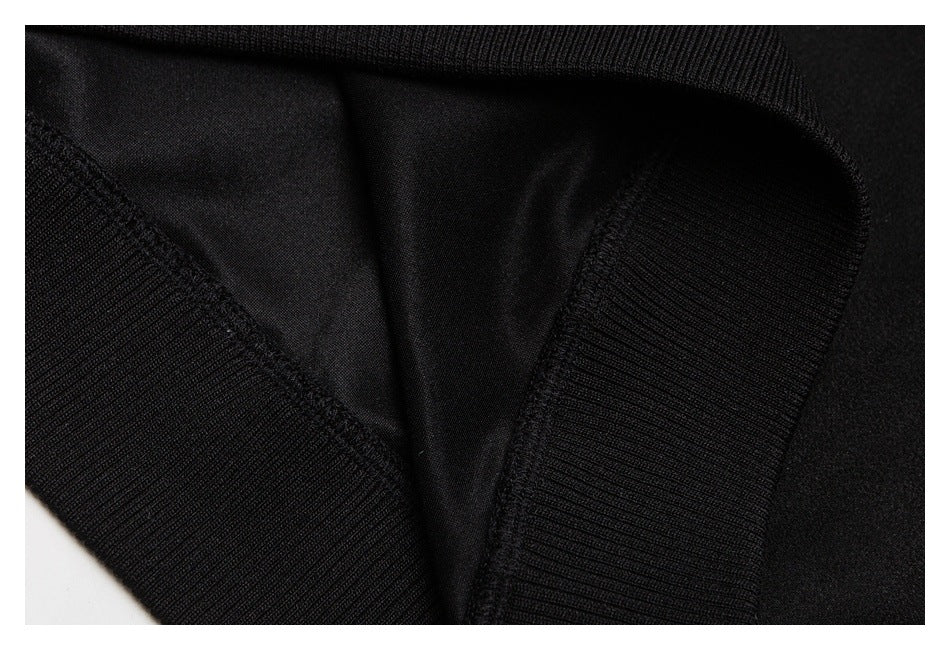 Close-up of the inside of a black garment with ribbed edging and visible seam stitching.