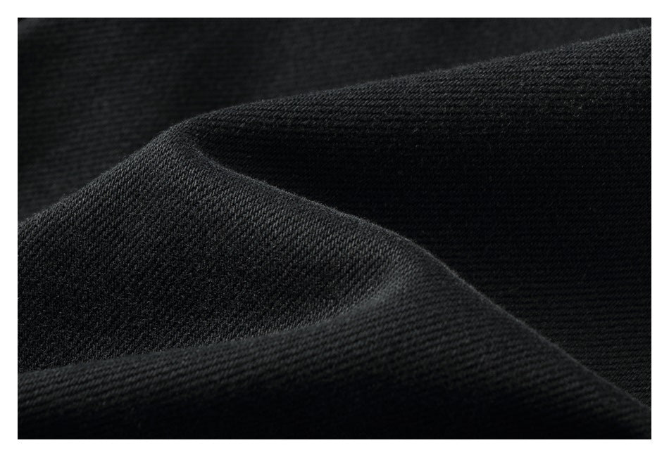 Close-up of the black garment's textured fabric and folded edge.