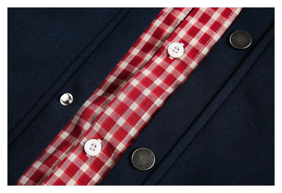 Close-up of the checked placket and contrasting buttons and snaps on navy fabric.