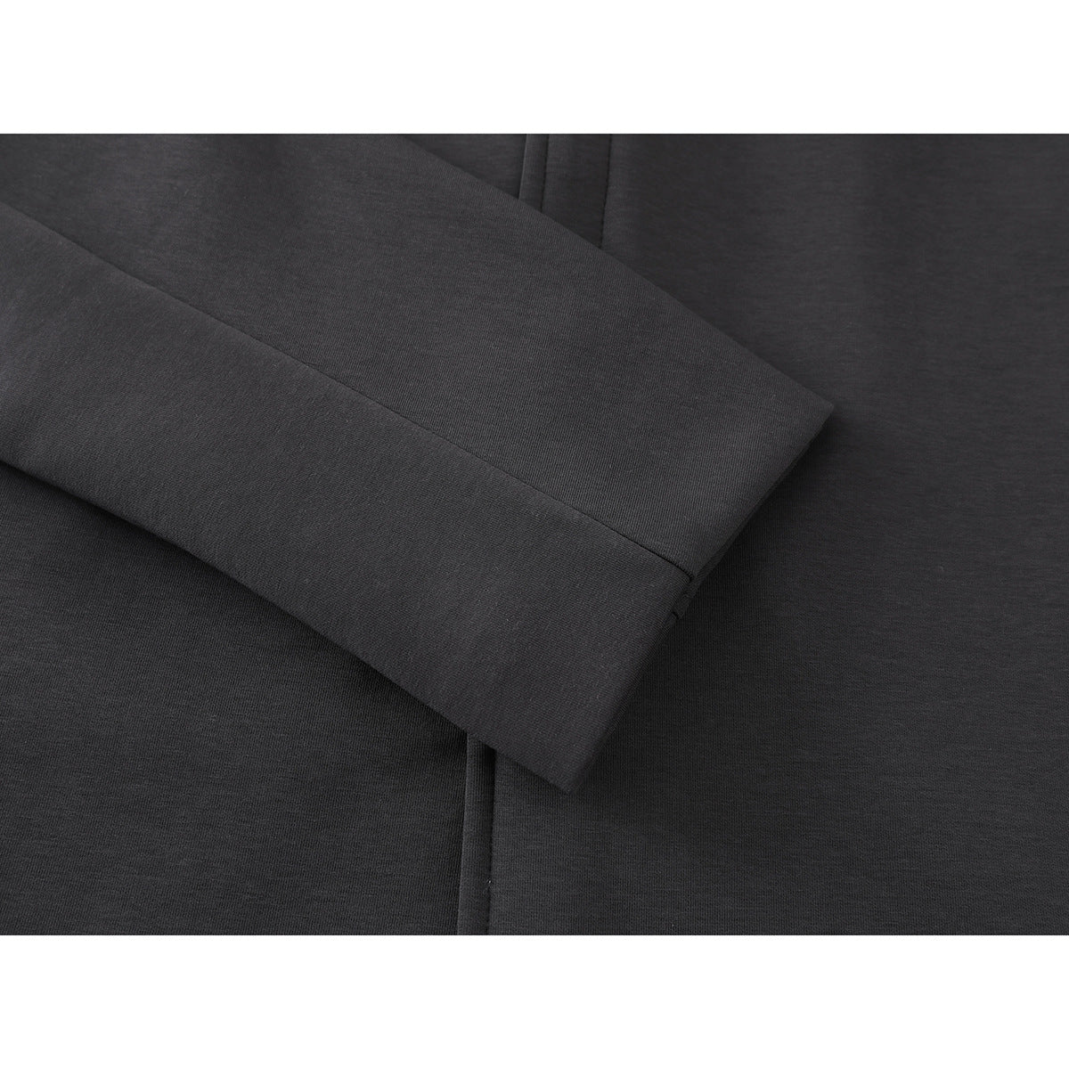 Close-up of a charcoal jacket sleeve and wide stitched cuff.