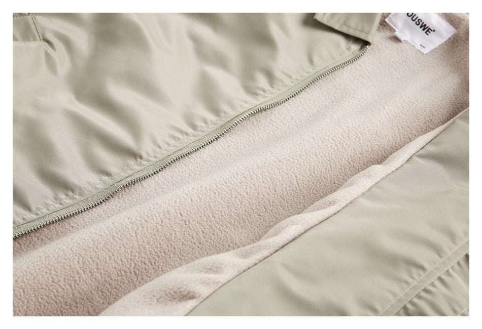Close-up of a light khaki jacket opened to show its pale fleece lining and zipper.