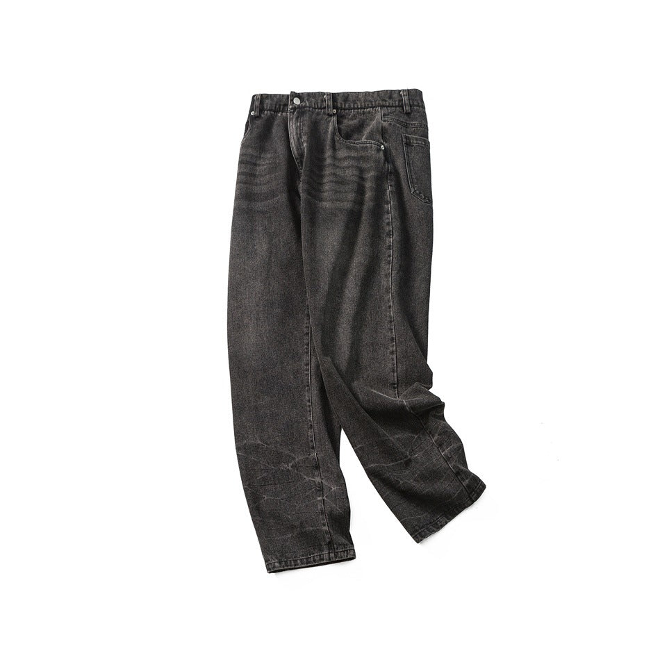 Full view of dark charcoal washed jeans laid flat, with a button fly, front pockets and loose straight legs.