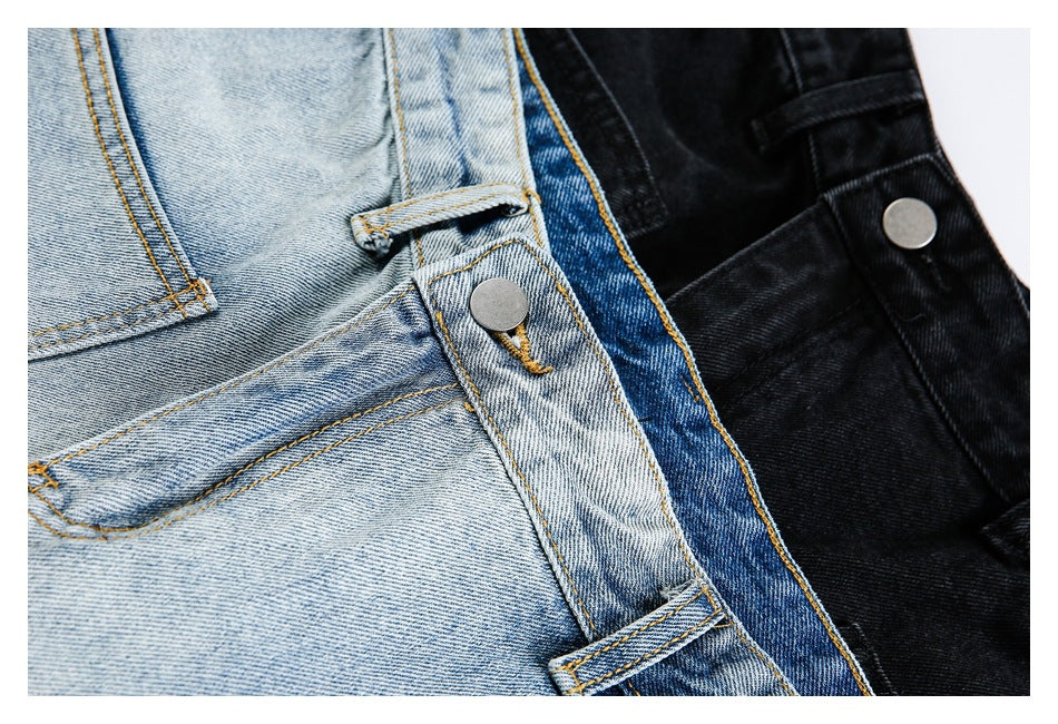 Close-up of light-wash and black jeans showing metal buttons, belt loops, waistband seams, and stitching.