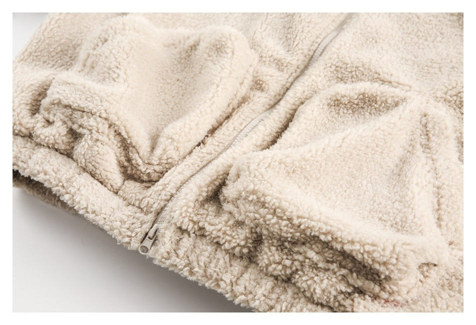 Close-up of the cream fuzzy jacket's lower front zipper and pocket area.
