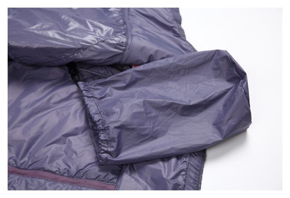 Close-up of a folded sleeve and gathered cuff on a shiny lavender-gray padded garment.