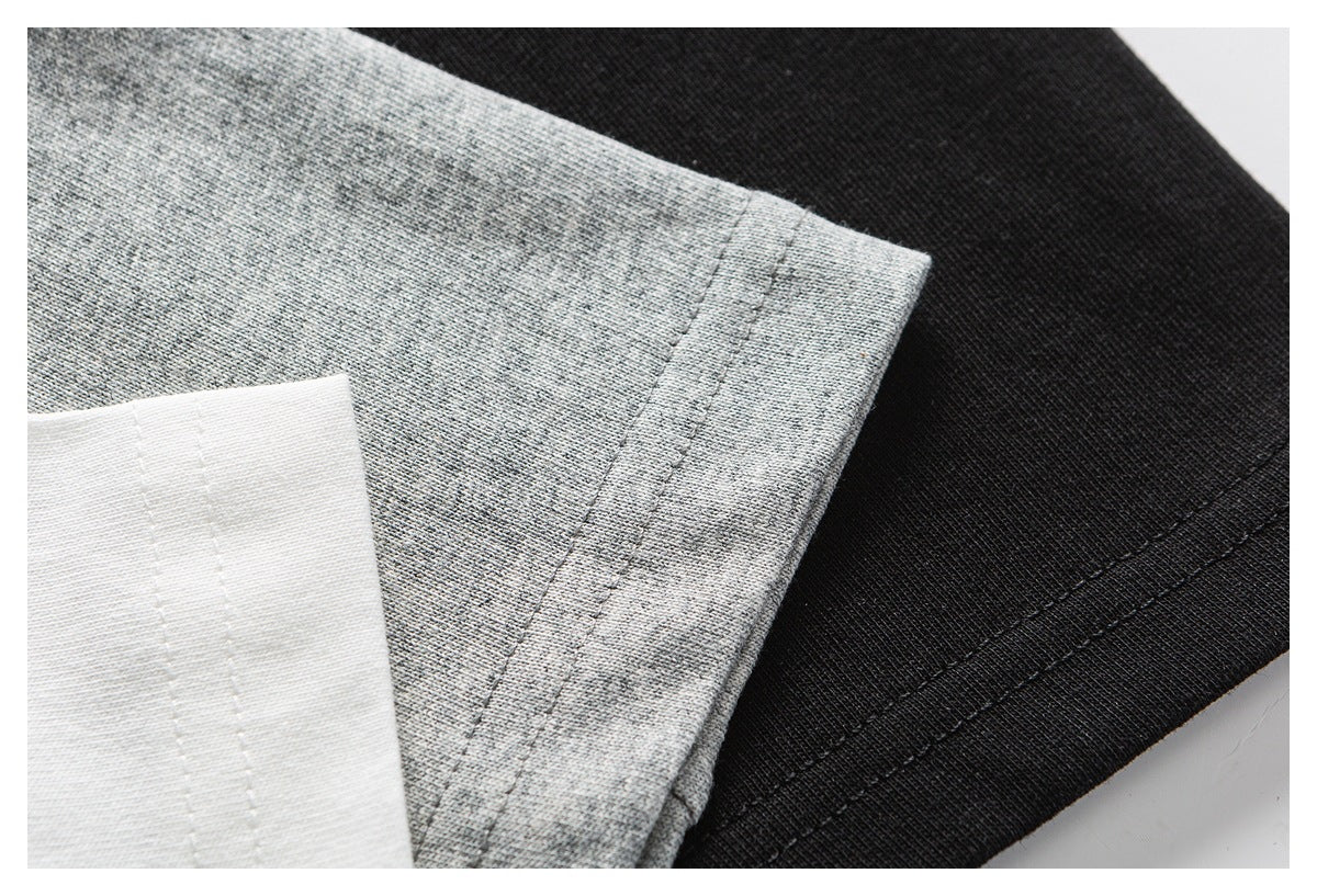 Close-up of gray, white, and black knit fabric edges with stitched hems.