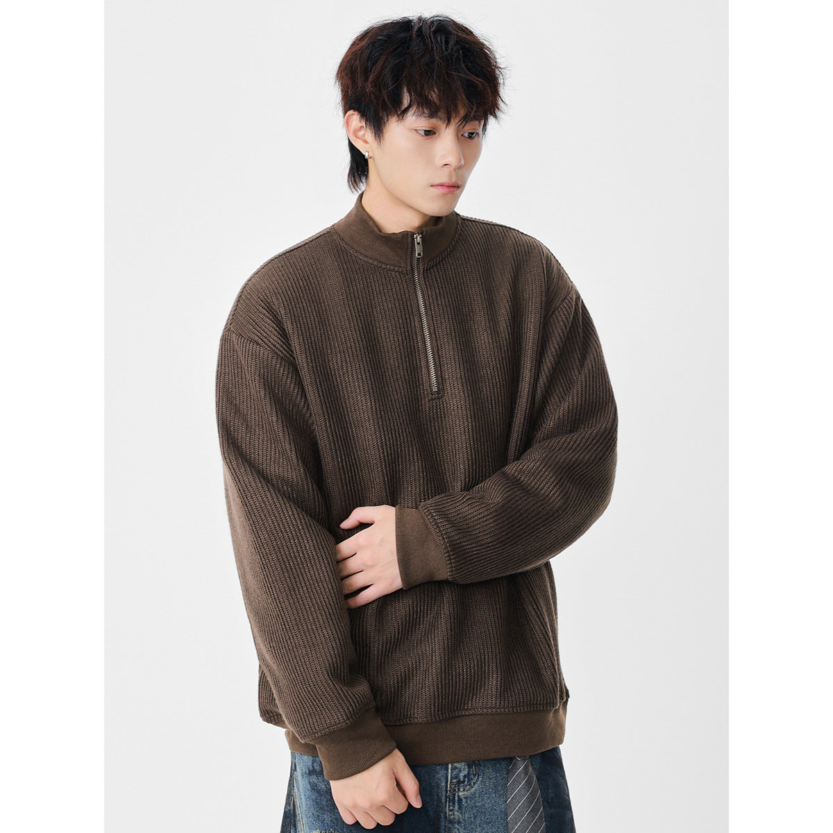 Model wearing a brown textured knit pullover with a short zip, stand collar, and ribbed cuffs and hem.