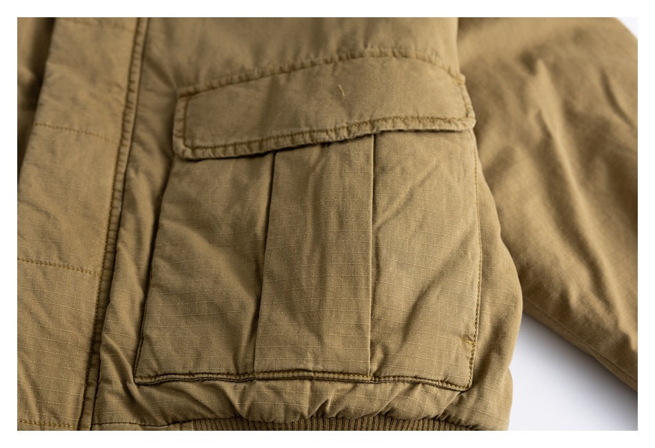 Close-up of a large flap pocket on an olive-brown jacket.