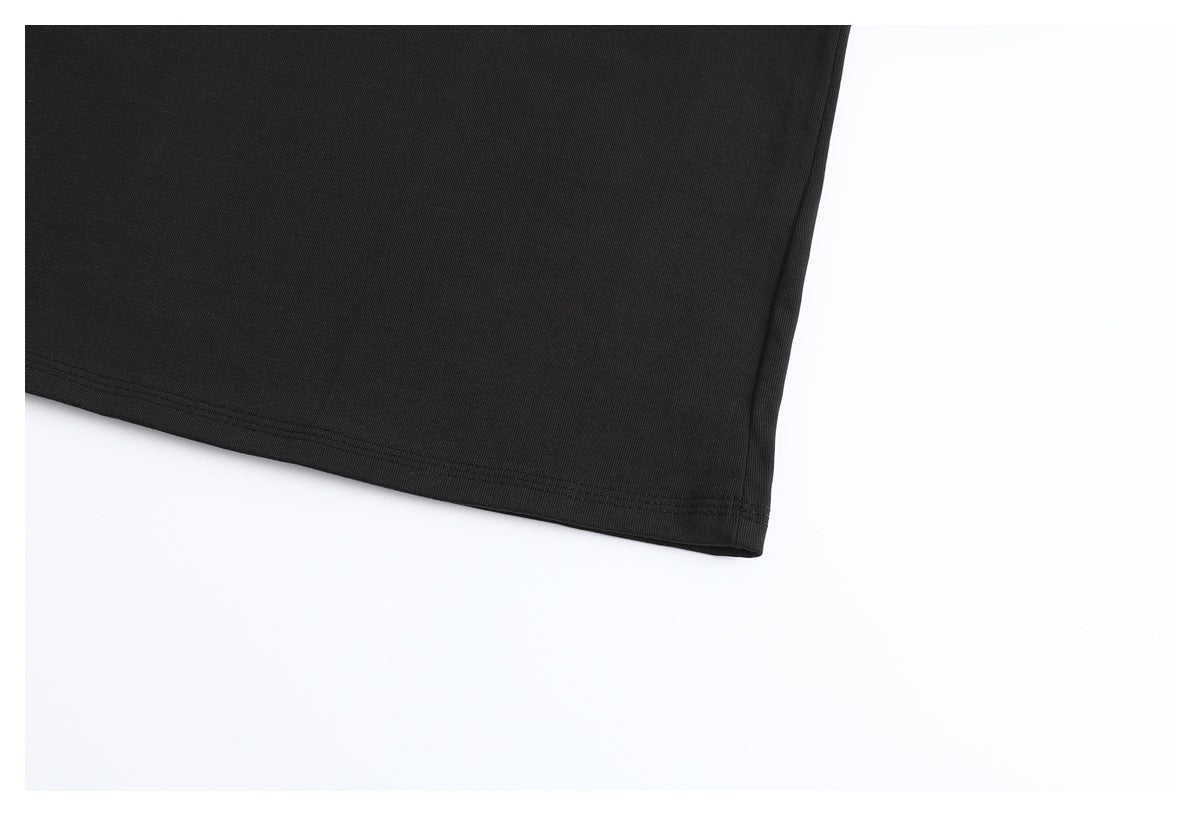 Close-up of the plain black T-shirt fabric and double-stitched bottom hem.