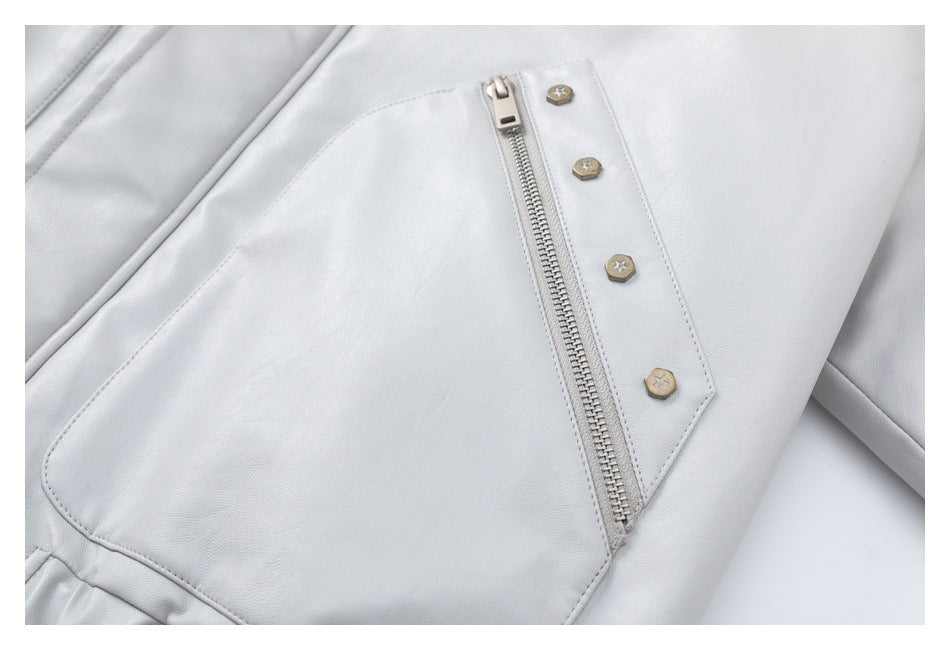 Close-up of a pale gray jacket pocket with a vertical zipper and decorative buttons.