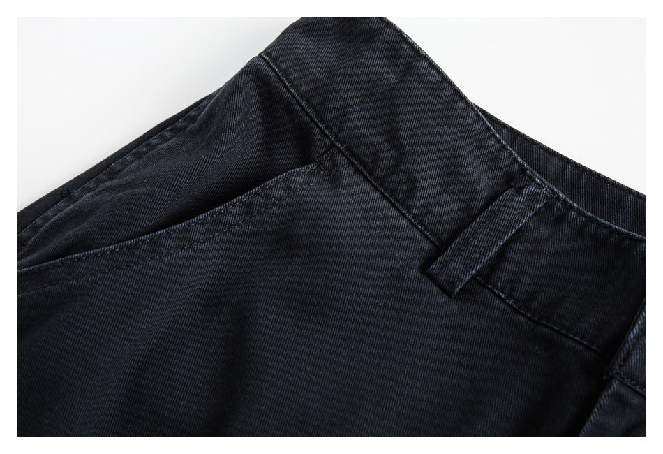 Close-up of black pants showing the curved front pocket, waistband, belt loop, and fabric texture.