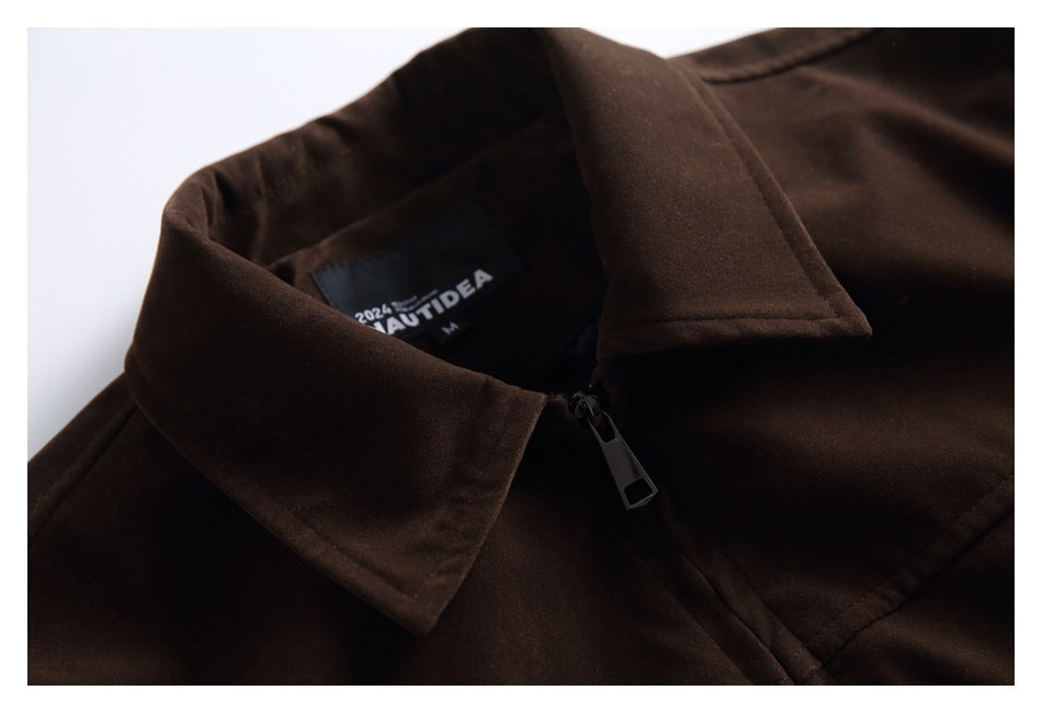 Close-up of the dark brown jacket's pointed collar, front zipper, and sewn-in neck label.