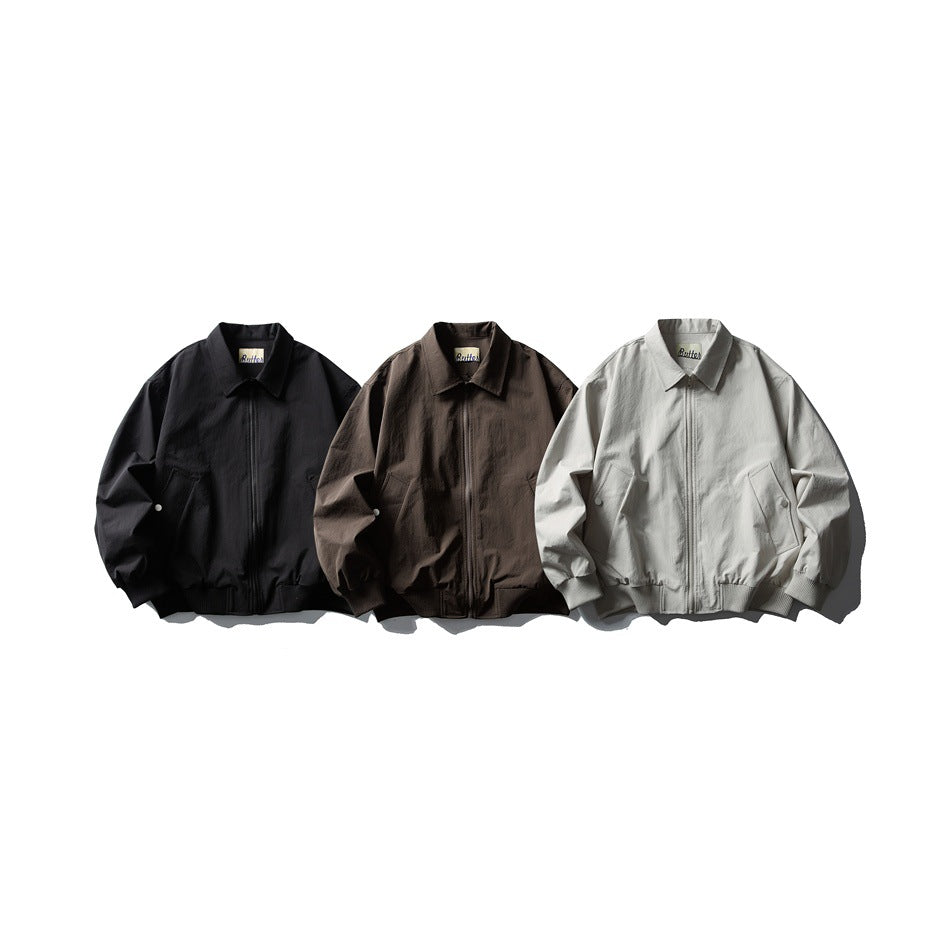 Three front-facing collared zip jackets in black, dark brown, and light gray, with ribbed cuffs and hems.