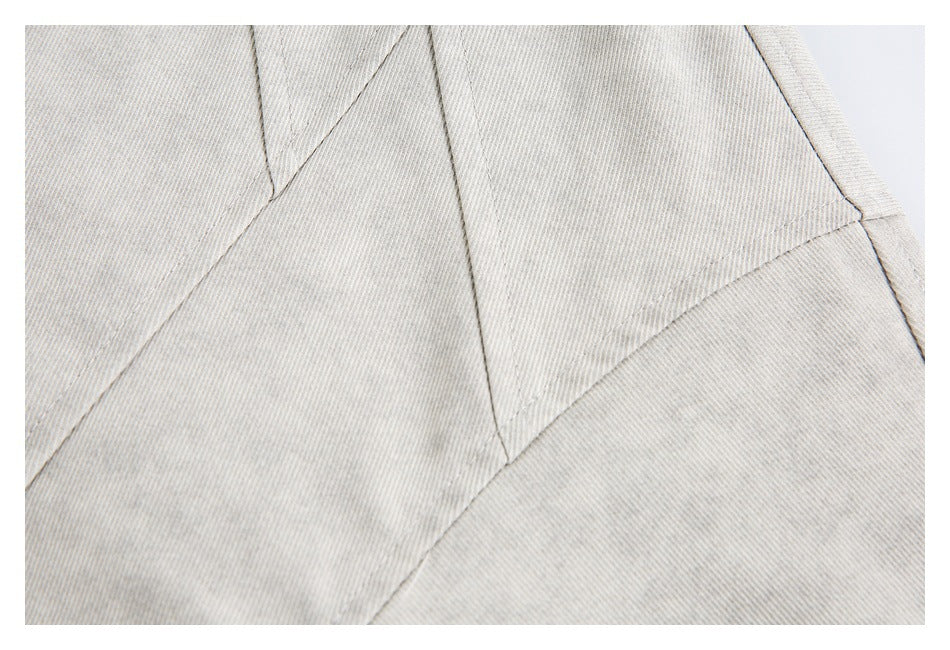Close-up of the light gray jacket's stitched panel seams.