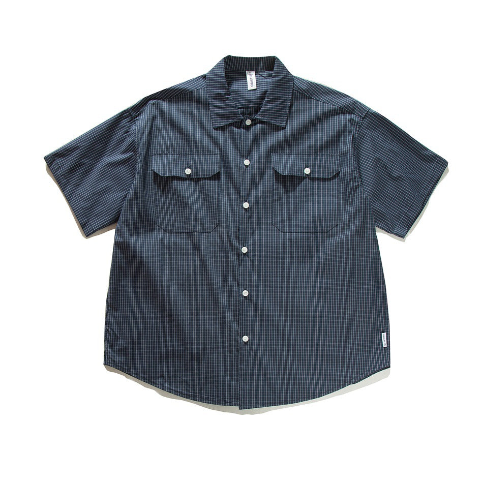 Navy short-sleeve button-up shirt with fine light grid check, two button-flap chest pockets, flat lay front view